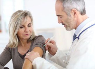 Lekarz szczepiący kobietę przeciw grypie