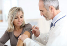 Lekarz szczepiący kobietę przeciw grypie